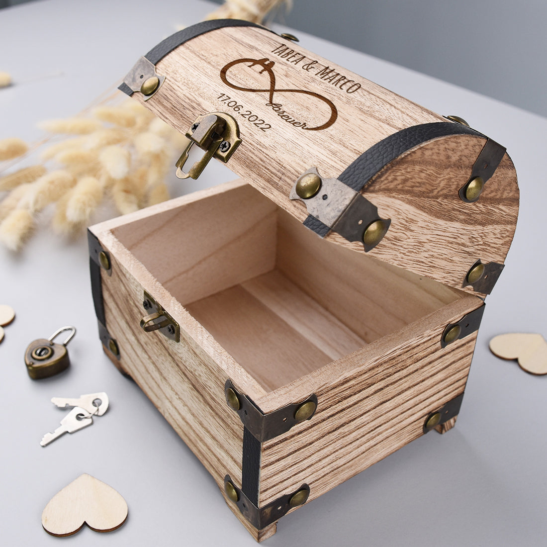 Leere geöffnete Holz-Schatztruhe mit Metallbeschlägen, Herzschloss und Schlüsseln