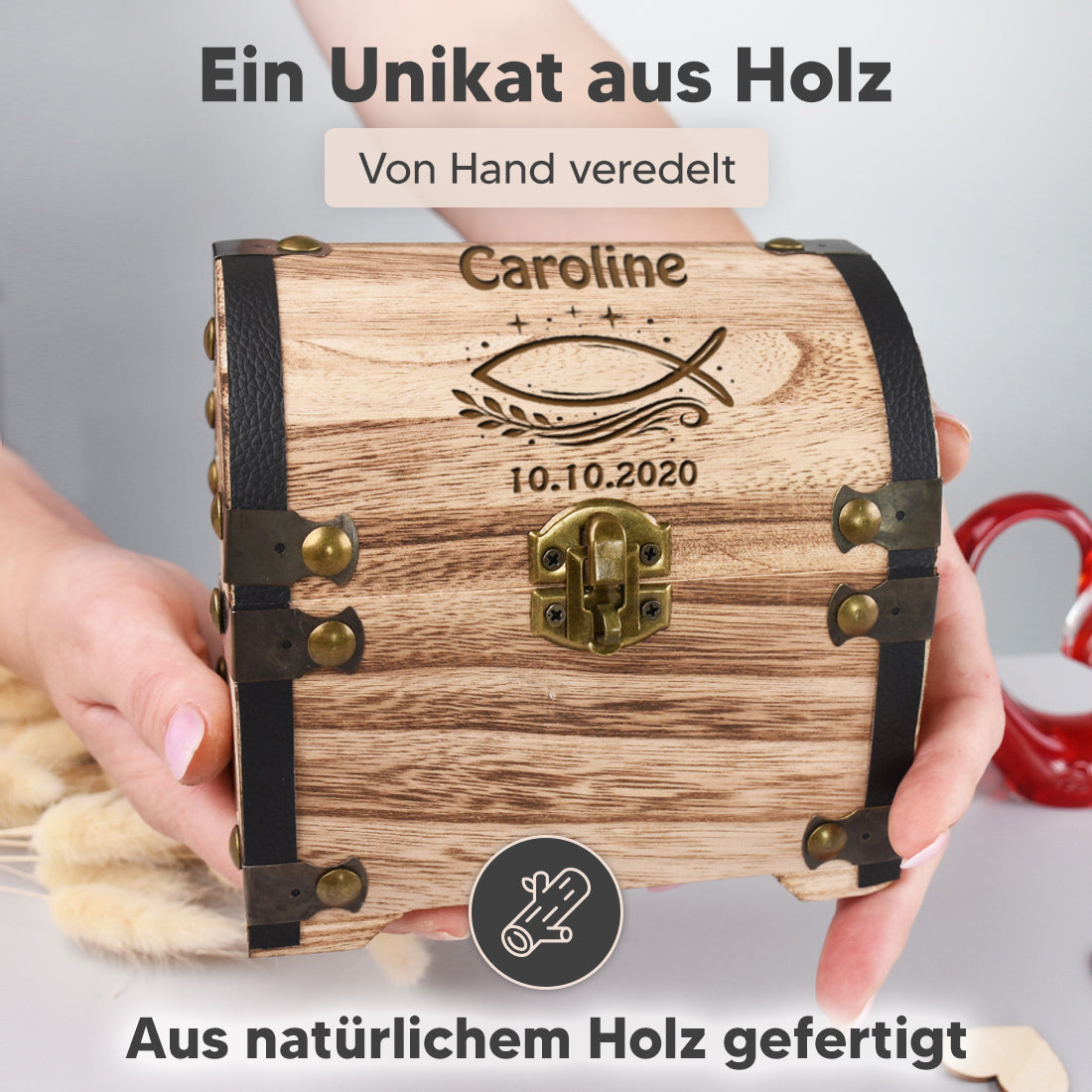 Hölzerne Schatzkiste mit dunklen Metallbeschlägen und einem goldenen Herz-Vorhängeschloss vor weißem Hintergrund.