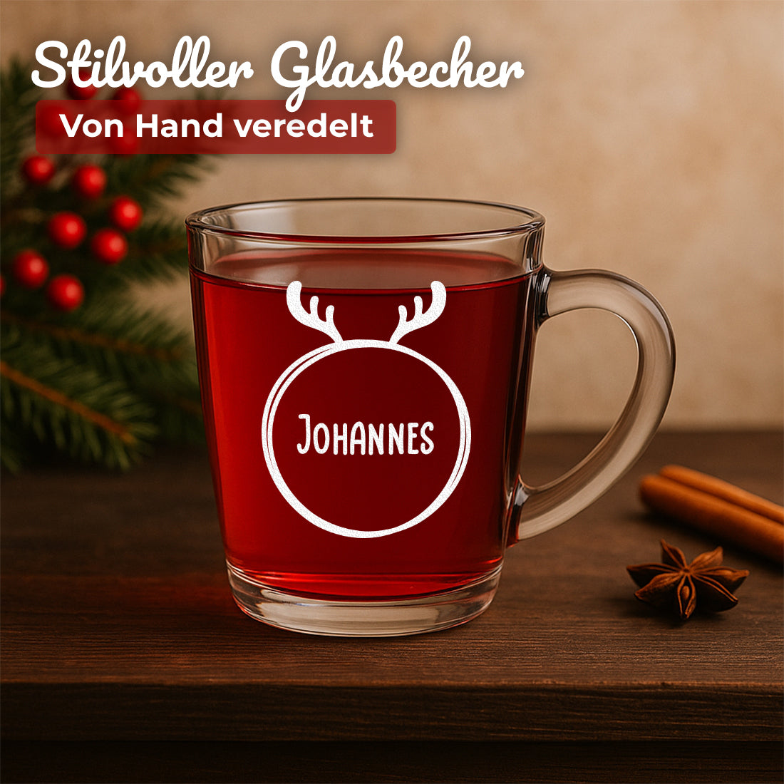 Glühweinglas mit Motiv Kreis mit Geweih und Beispielgravur Johannes auf einem weihnachtlichen Tisch