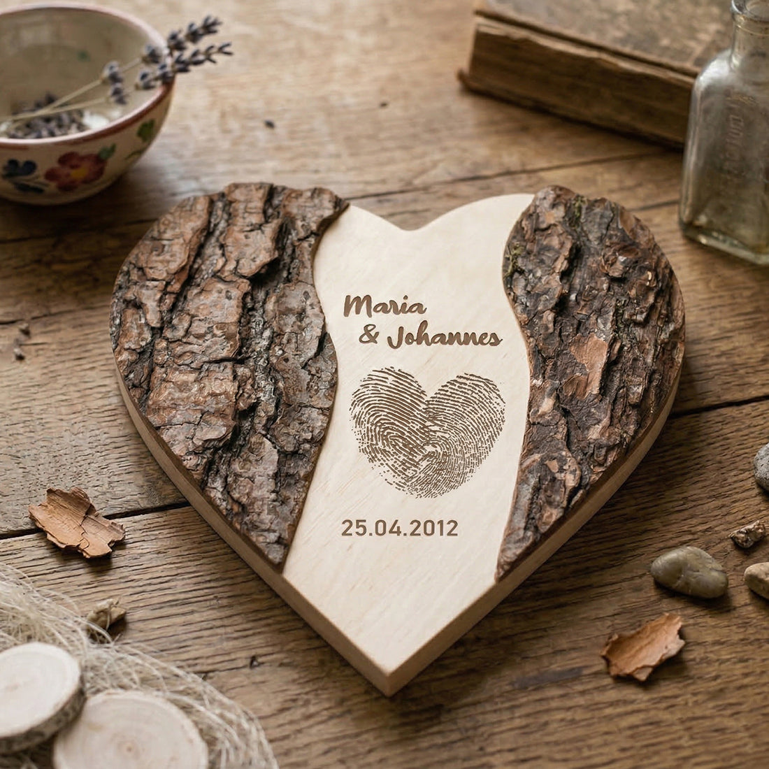 Personalisiertes Holzherz zur Hochzeit mit Rinde und gravierten Namen 'Maria & Johannes' sowie Datum und Fingerabdruck.