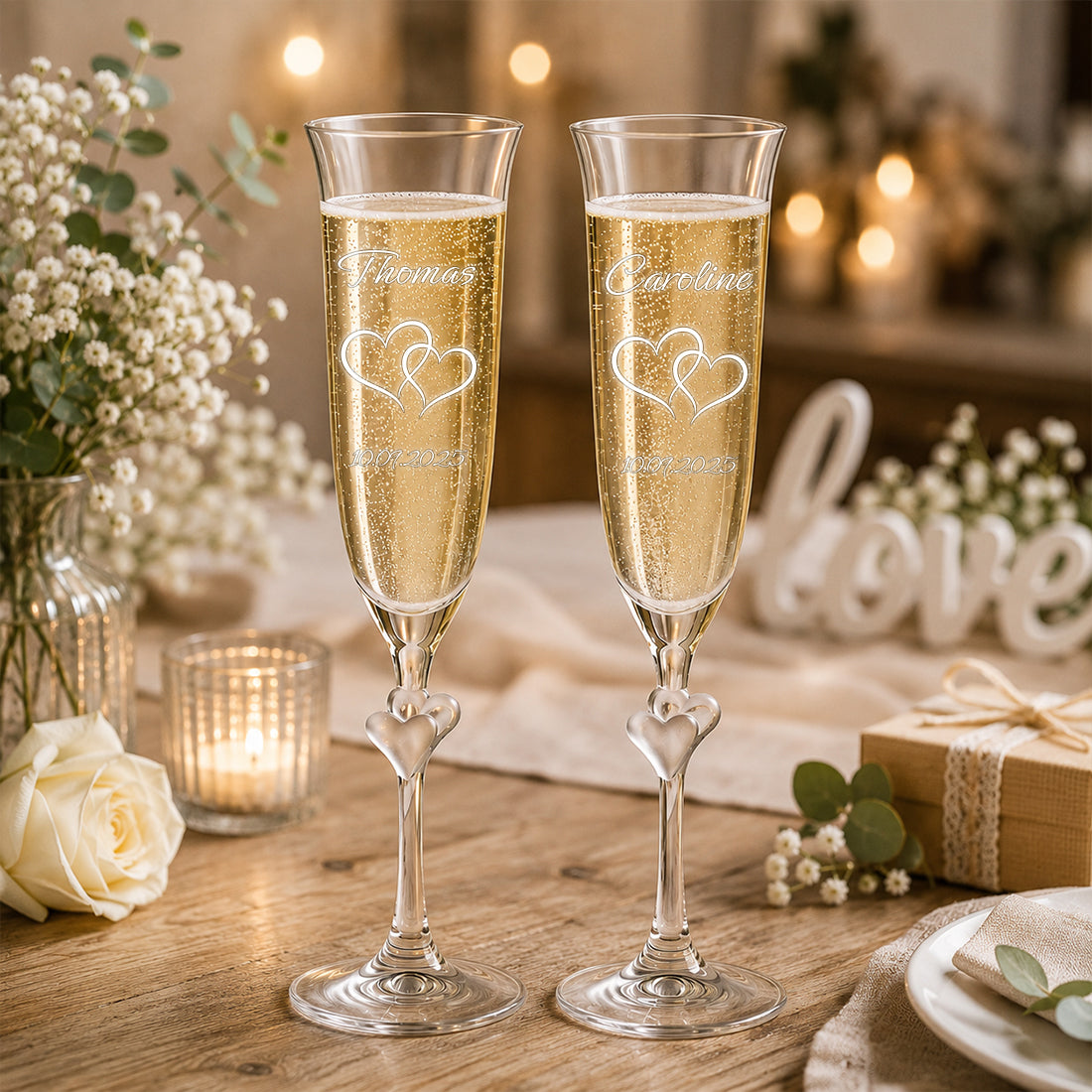 Sektgläser mit satinierten Herzen im Glasstiel auf festlich geschmücktem Hochzeitstisch.