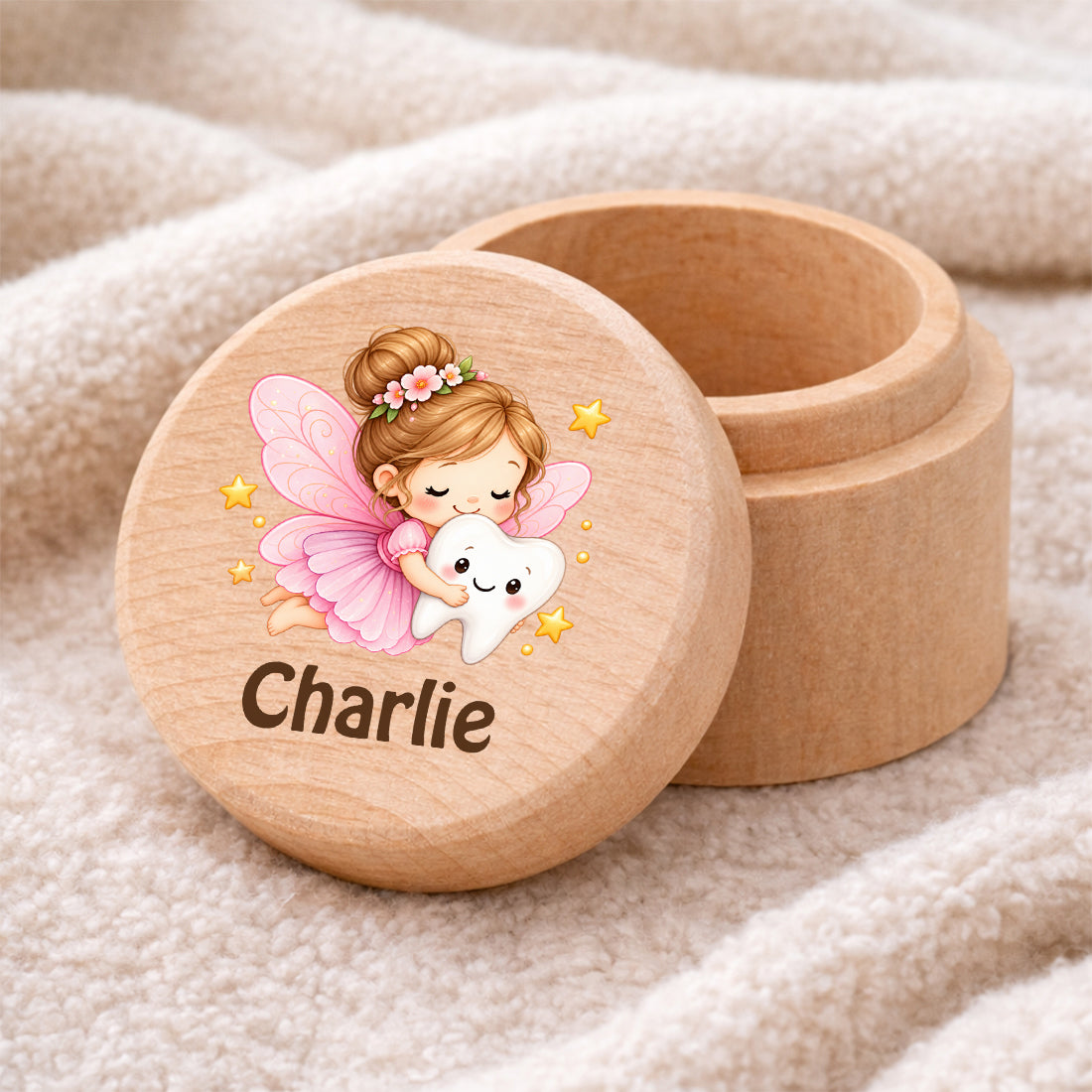 Runde Zahndose mit Motiv Zahnfee und Beispielname Charlie auf einer weichen Decke