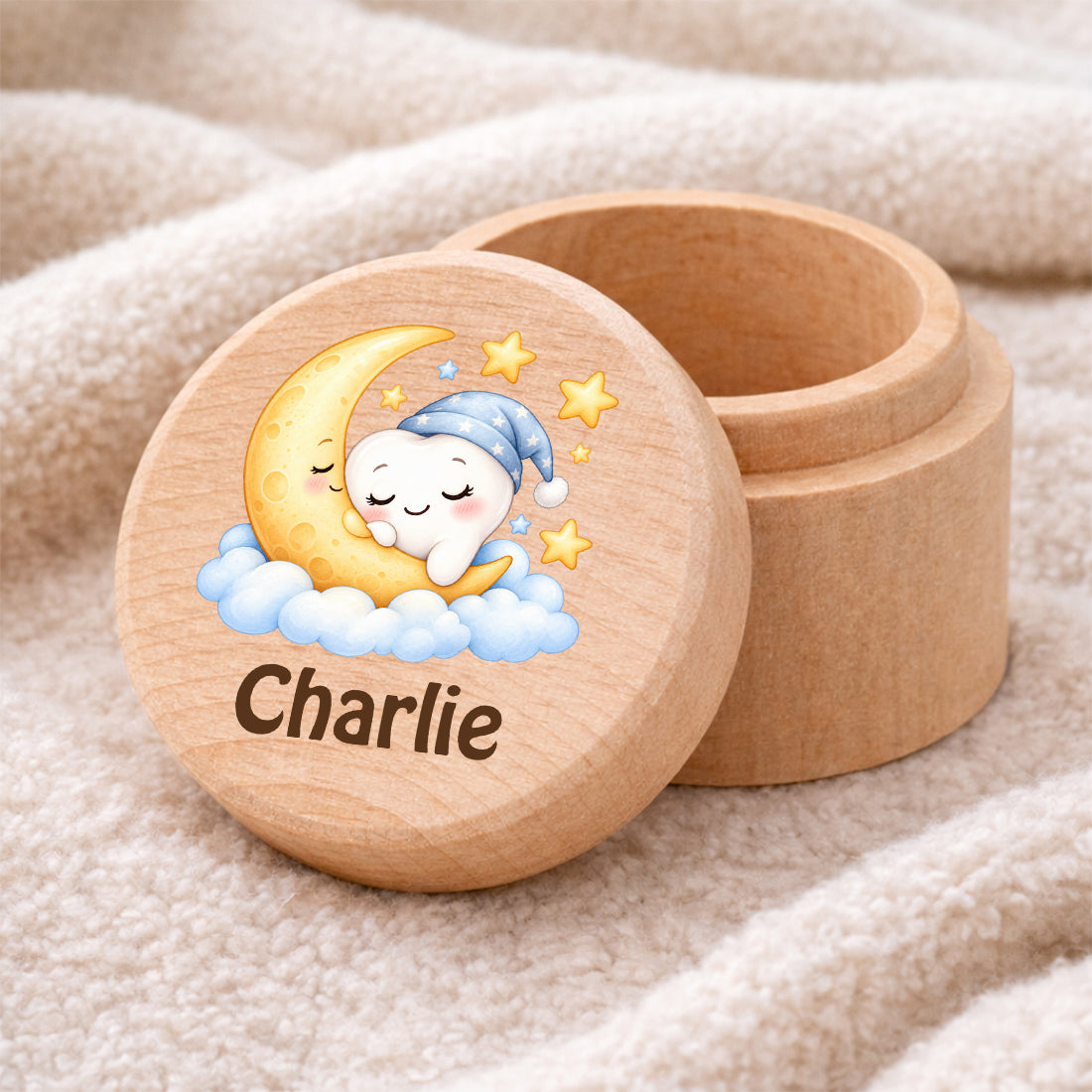 Runde Zahndose mit Motiv Mond & Zahn und Beispielname Charlie auf einer weichen Decke