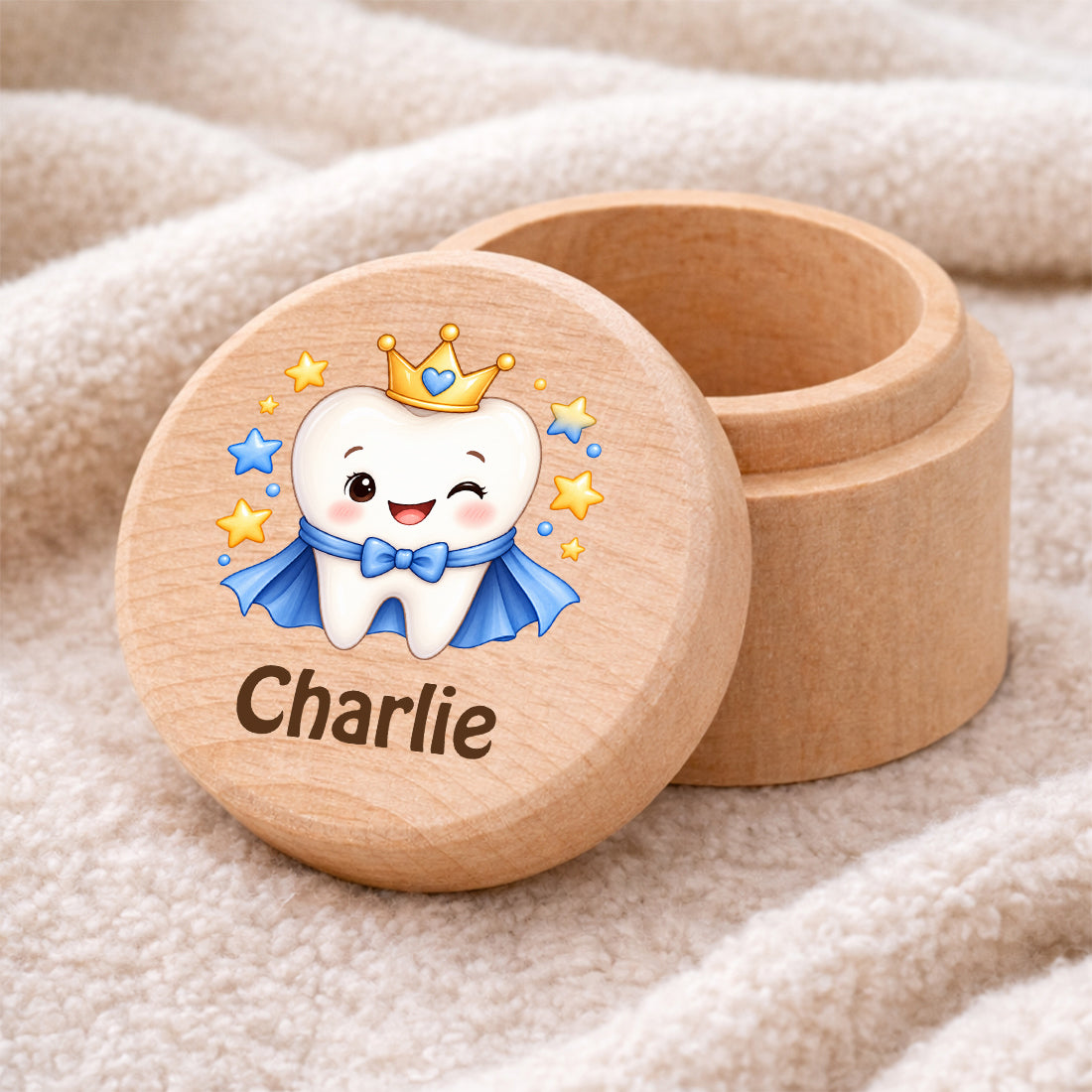 Runde Zahndose mit Motiv Zahnprinz und Beispielname Charlie auf einer weichen Decke