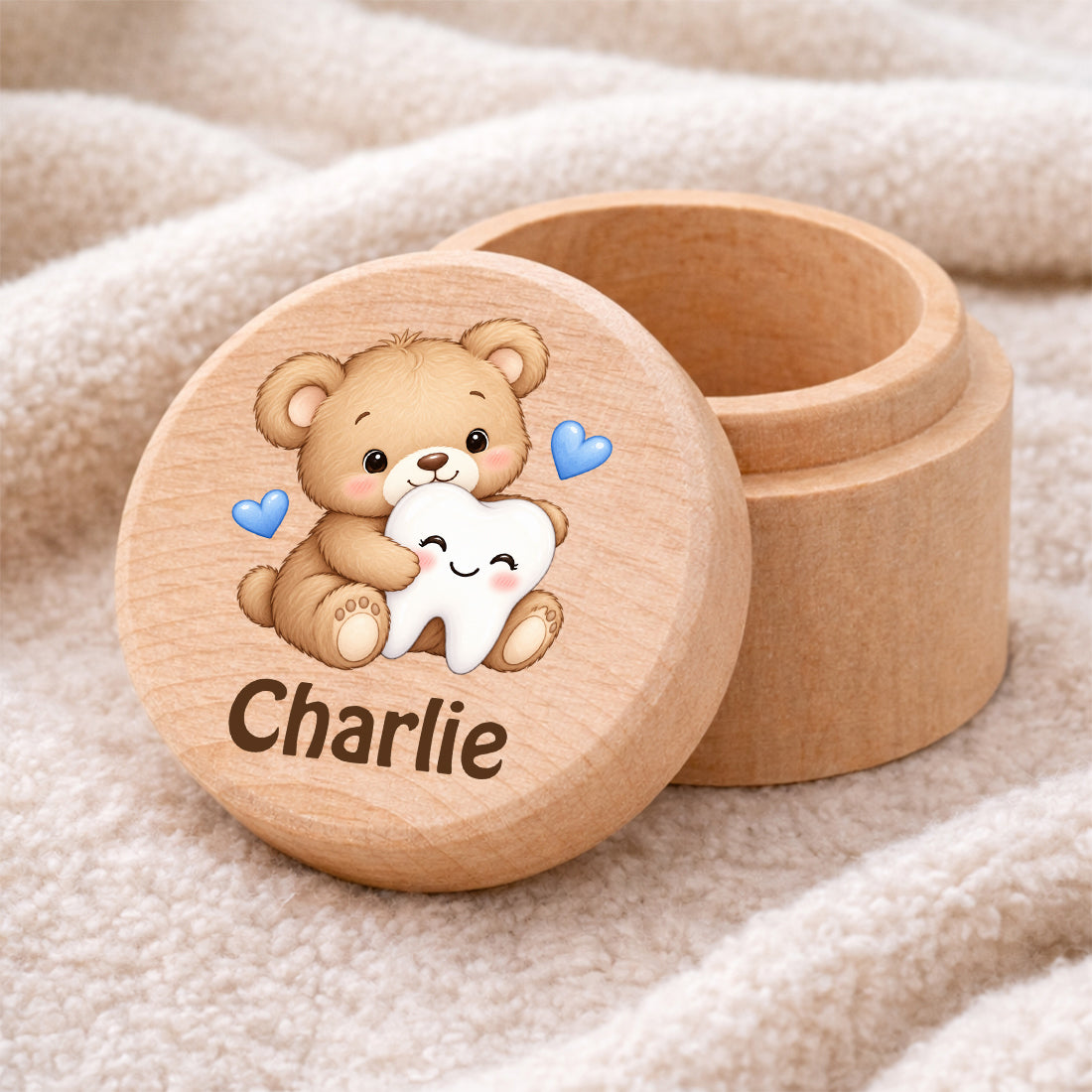 Runde Zahndose mit Motiv Teddybär & Zahn und Beispielname Charlie auf einer weichen Decke