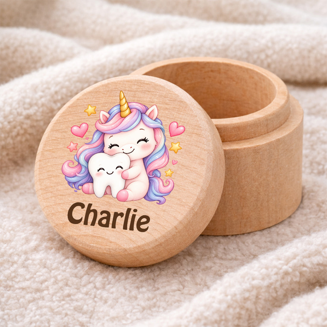 Runde Zahndose mit Motiv Einhorn & Zahn und Beispielname Charlie auf einer weichen Decke