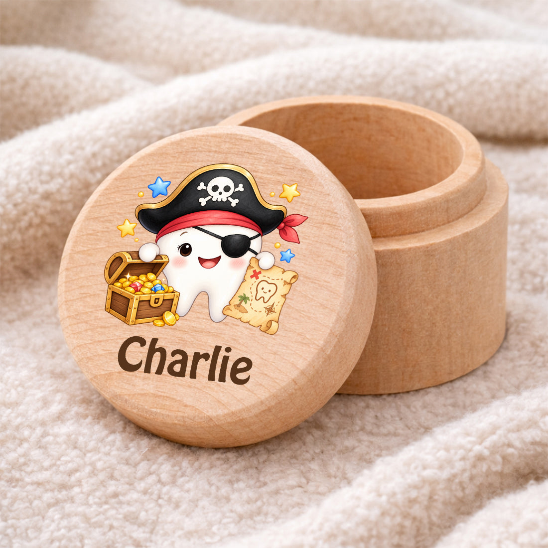 Runde Zahndose mit Motiv Zahn-Pirat und Beispielname Charlie auf einer weichen Decke
