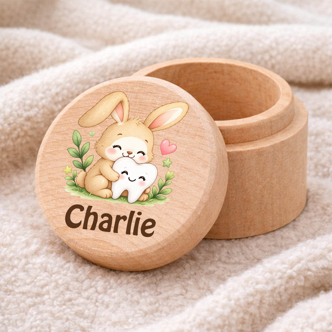 Runde Zahndose mit Motiv Hase & Zahn und Beispielname Charlie auf einer weichen Decke