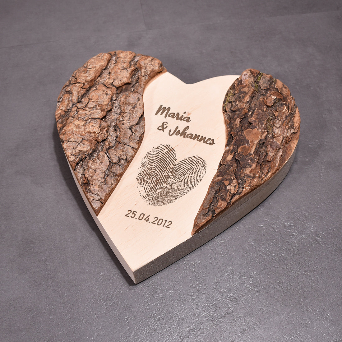 Personalisierbare Holzscheibe in Herzform mit Rindenrand als rustikale Wanddekoration oder Aufsteller für das Zuhause.