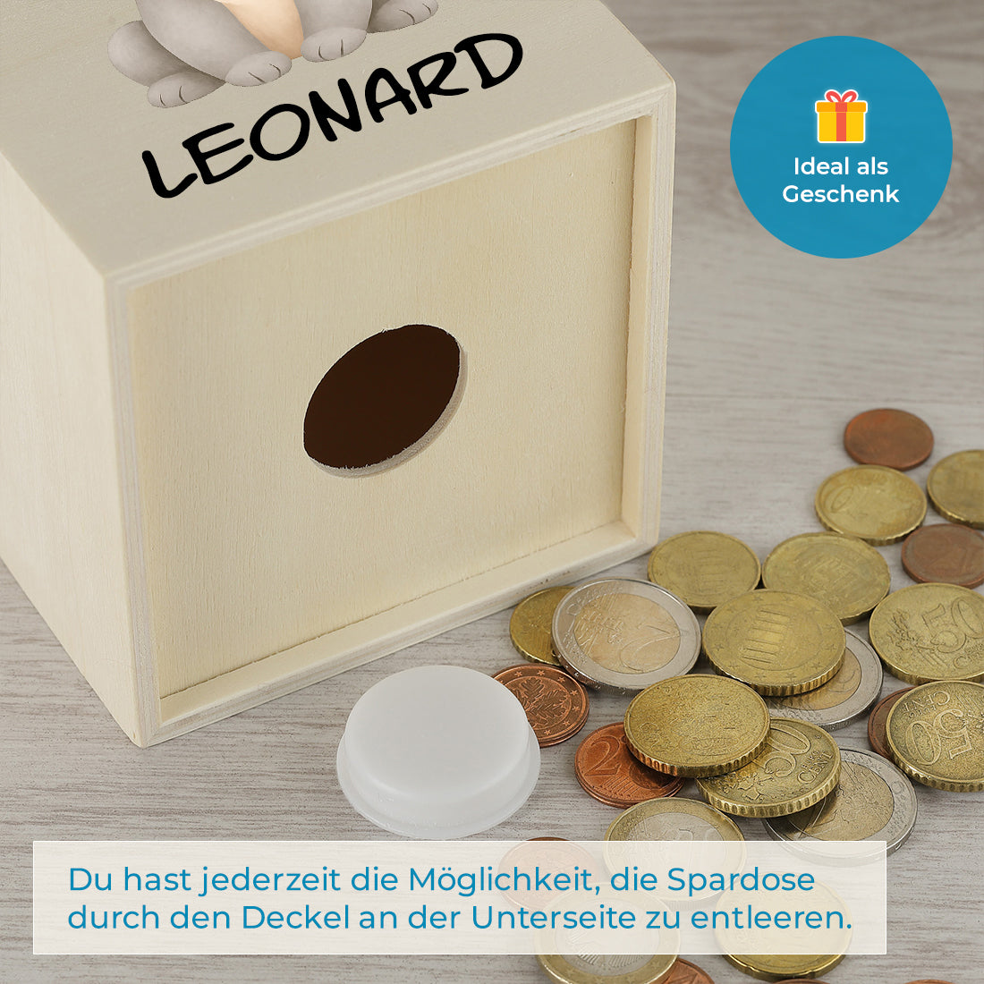 Geöffnete Bodenöffnung der Holzspardose mit herausgenommenem Verschluss und Münzen.
