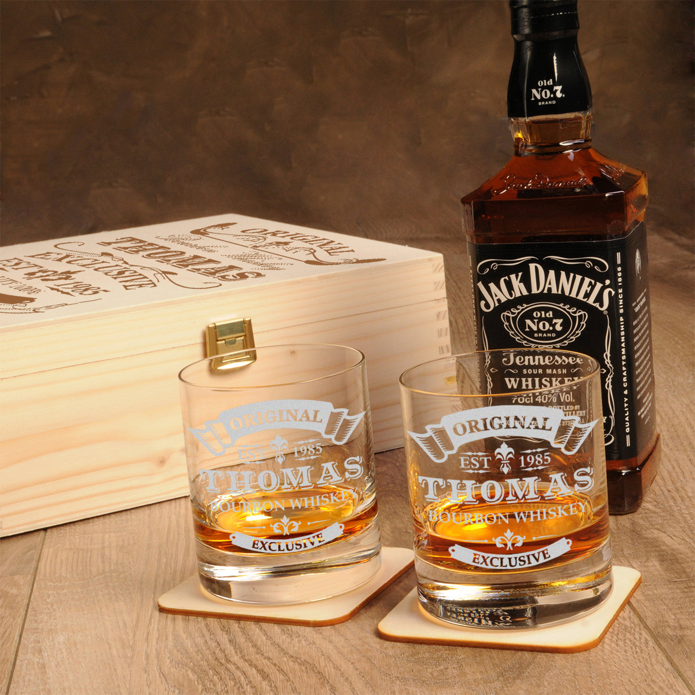 Personalisiertes Whiskyglas Thomas mit Eiswürfel befüllt auf dem passenden, gravierten Holzuntersetzer.